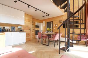 a kitchen and dining room with a spiral staircase in a house at Osada Joniec in Joniec