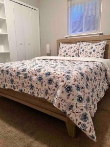 um quarto com uma cama com um edredão floral em Cozy Bungalow in Madison Heights em Madison Heights