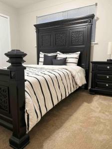 um quarto com uma cama grande e uma cabeceira preta em Cozy Bungalow in Madison Heights em Madison Heights