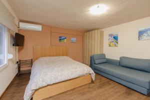 a bedroom with a bed and a blue couch at FAOS Properties in Kavala