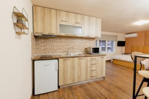 eine Küche mit einer Spüle und einem Kühlschrank sowie ein Schlafzimmer in der Unterkunft FAOS Properties in Kavala