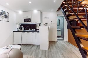 a kitchen with white cabinets and a spiral staircase at Aria in Cetinje
