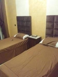 - une chambre avec 2 lits dans l'établissement Bel Appartement pour vacances, à Sidi Rahal