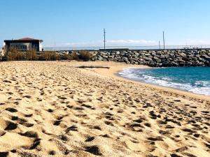 une plage avec des empreintes de pieds dans le sable à côté de l'eau dans l'établissement Apartamento playa, à Arenys de Mar