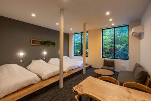 上田市にある別所温泉 緑屋のベッドルーム1室(ベッド2台、ソファ、テーブル付)