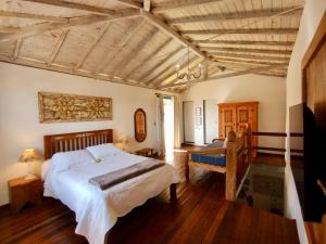 1 dormitorio con 1 cama grande y techo de madera en Cantinho Almeida, en Tiradentes