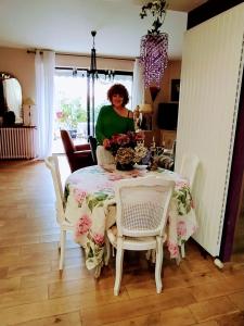 a woman standing at a table with a table cloth at Chambre d'hôtes chez Claude Bardou in Lacrouzette