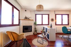 a living room with a fireplace and chairs at Wasi Compostela in Santiago de Compostela