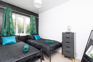 a bedroom with two beds and a window at Easterly Contractor Home - Free Parking, Self Check-in, Wi-Fi, Pool Table, Table Tennis, Air Hockey, Excellent Access to Leeds Centre in Roundhay