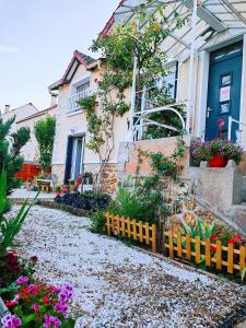 une maison ornée de fleurs et d'une clôture jaune dans l'établissement House 100m2 with Garden and BBQ 20 min from Paris, à Épinay-sur-Orge