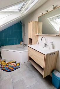 La salle de bains est pourvue d'un lavabo, d'une baignoire et d'un miroir. dans l'établissement House 100m2 with Garden and BBQ 20 min from Paris, à Épinay-sur-Orge