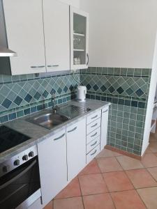 - une cuisine avec des placards blancs et un évier dans l'établissement Apartment Antonia, à Dobova
