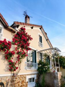 une maison avec des fleurs rouges sur son côté dans l'établissement House 100m2 with Garden and BBQ 20 min from Paris, à Épinay-sur-Orge