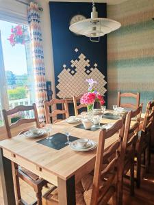 une table en bois avec des chaises et une salle à manger dans l'établissement House 100m2 with Garden and BBQ 20 min from Paris, à Épinay-sur-Orge