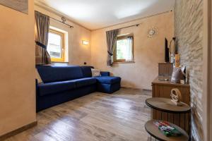 sala de estar con sofá azul y 2 mesas en Chalet Sunshine, en Livigno