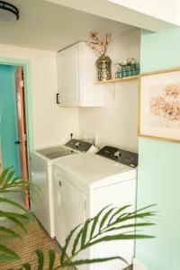 uma cozinha com uma máquina de lavar roupa e um lavatório em Isle See You At the Beach em Emerald Isle