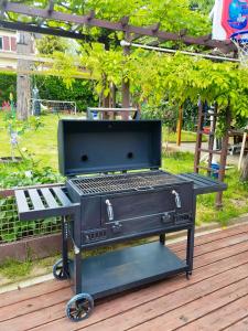 - un barbecue installé sur une terrasse en bois dans l'établissement House 100m2 with Garden and BBQ 20 min from Paris, à Épinay-sur-Orge