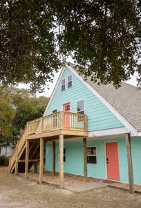 a house with a deck on the side of it at Isle See You At the Beach in Emerald Isle