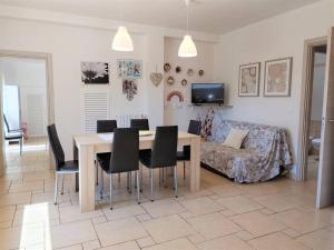 ein Wohnzimmer mit einem Tisch, Stühlen und einem Sofa in der Unterkunft Villa Sant'Oceano in Monopoli
