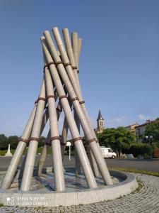 a sculpture of a stack ofrights in a park at Chambre d'hôtes chez Claude Bardou in Lacrouzette