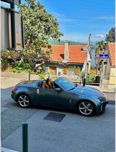 a blue convertible car parked on the street at Apartman Volosko in Opatija