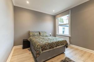a bedroom with a bed and a window at Cozy 3-Bedroom Flat in Willesden Green London in London