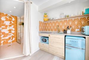 cocina con armarios de madera y lavavajillas azul en HOUS - Ocean Park - Pool - Sunset Lounge, en San Juan