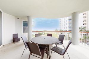 a dining room with a table and chairs on a balcony at Beach Colony Resort West 2F in Navarre