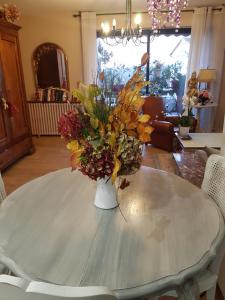 un jarrón de flores sentado sobre una mesa en Chambre d'hôtes chez Claude Bardou en Lacrouzette