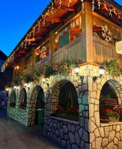 ein Gebäude mit einer Steinmauer mit Blumen darauf in der Unterkunft Villa Miris Dunja in Zlatibor