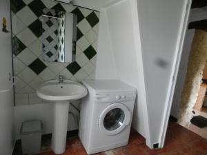 uma casa de banho com uma máquina de lavar roupa e um lavatório em gîtes de Combelcau, le Pigeonnier em Flaugnac