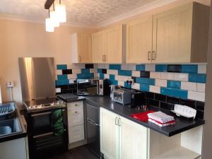 a kitchen with blue and white tiles on the wall at The Hay Barn in Sibsey