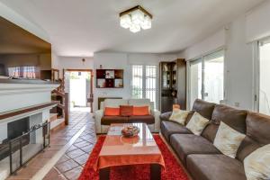 Villa Duquesa في مانيلفا: غرفة معيشة مع أريكة ومدفأة