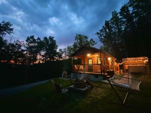 a tiny house sitting in a yard at night at Dreamy Couples Cabin in the Shenandoah Forrest in Luray