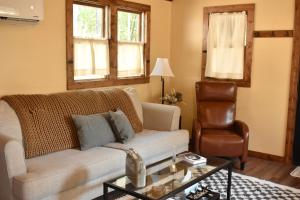 ein Wohnzimmer mit einem Sofa und einem Stuhl in der Unterkunft Dreamy Couples Cabin in the Shenandoah Forrest in Luray