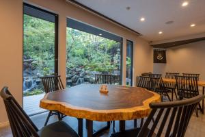 a dining room with a wooden table and chairs at Bessho Onsen Midoriya in Ueda