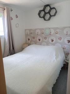 a bedroom with a white bed with a wall with hearts at Mobile Home in Avrillé