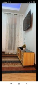 a living room with a flat screen tv on a wall at Rj condotel @arezzo place davao in Davao City