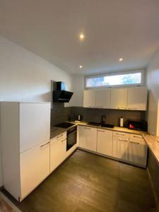 a kitchen with white cabinets and a large window at Bronzetaler in Bad Harzburg