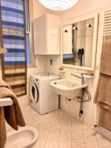 Appartamento 150 mq vicino al mare في كاتوليكا: حمام مع غسالة ومغسلة