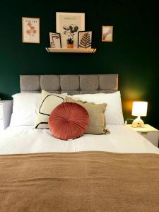 uma grande cama branca com uma almofada vermelha em Homebird Property - Buckton House em Leeds