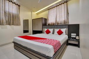 a bedroom with a large bed with red pillows at Hotel Dhiman Residency in Mumbai
