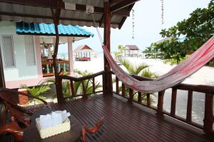 a hammock on a porch with a view of the beach at Nice Sea Resort in Srithanu