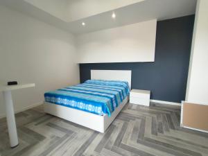 ein Schlafzimmer mit einem Bett mit einer blauen Decke in der Unterkunft Stanza idromassaggio 2 in Quartu SantʼElena