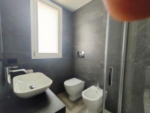 ein Bad mit einem WC, einem Waschbecken und einer Dusche in der Unterkunft Stanza idromassaggio 2 in Quartu SantʼElena