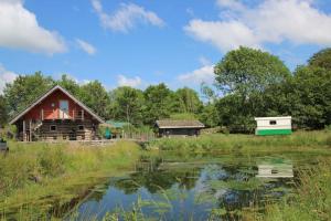 un granero y una casa junto a un estanque en Chalet au bord d'un étang privé, Massif du Sancy, en Picherande