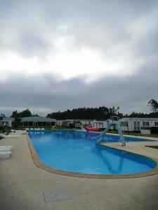 a large swimming pool with a slide in the middle at Bungalow privado Tilda - na Landshouse in Burinhosa