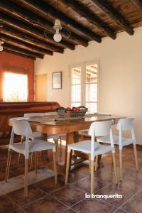a dining room with a wooden table and white chairs at Finca La Tranquerita in San Rafael