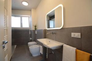 uma casa de banho com um lavatório, um WC e um espelho. em FABIO a Marina di Pisa em Marina di Pisa