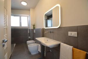 Un baño con lavabo, inodoro y espejo. en FABIO a Marina di Pisa, en Marina di Pisa